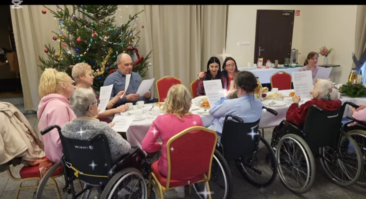 Screen z filmiku konkursowego na którym wszyscy siedzą przy wigilijnym stole