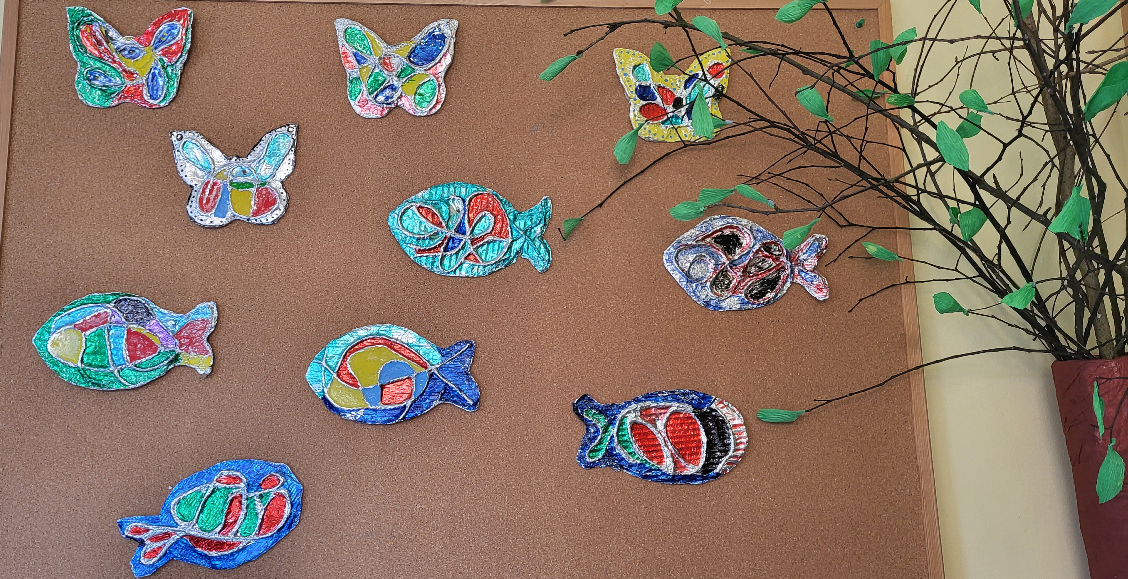motyle i ryby wykonane podczas Arterapii przez mieszkańców dps przyczepione na tablice korkową 